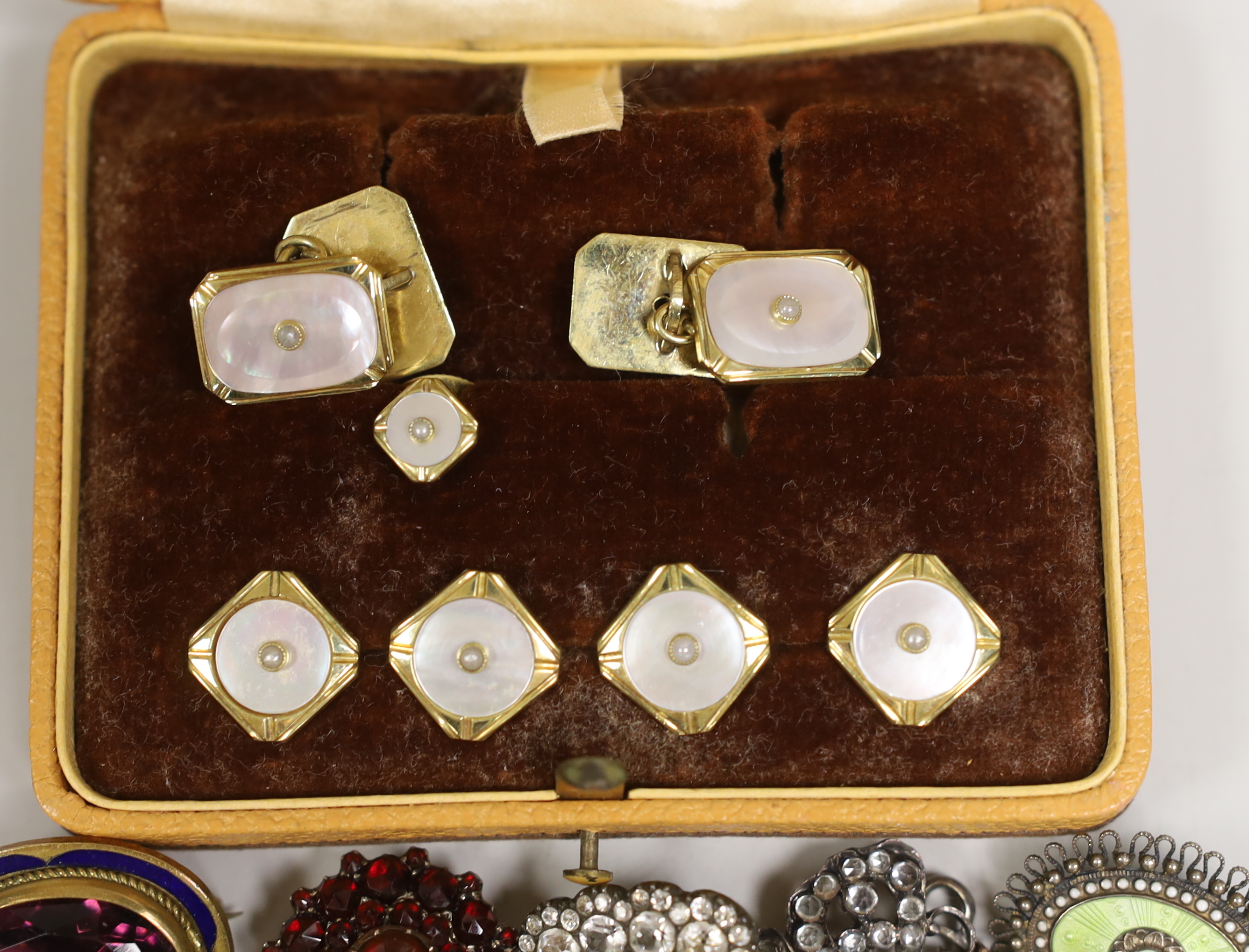 Victorian and later jewellery including a gilt metal, amethyst paste and enamelled oval brooch, 26mm, a garnet set mourning brooch with plaited hair, two paste set brooches, a cased dress stud set and a Scandinavian 830s